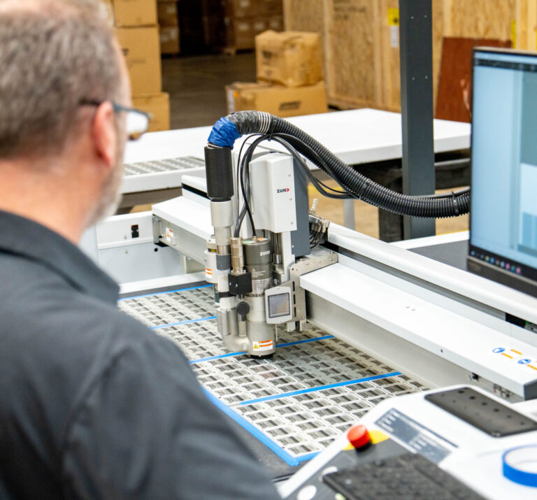 Print Source Employee running the Zünd Digital CNC Cutter.