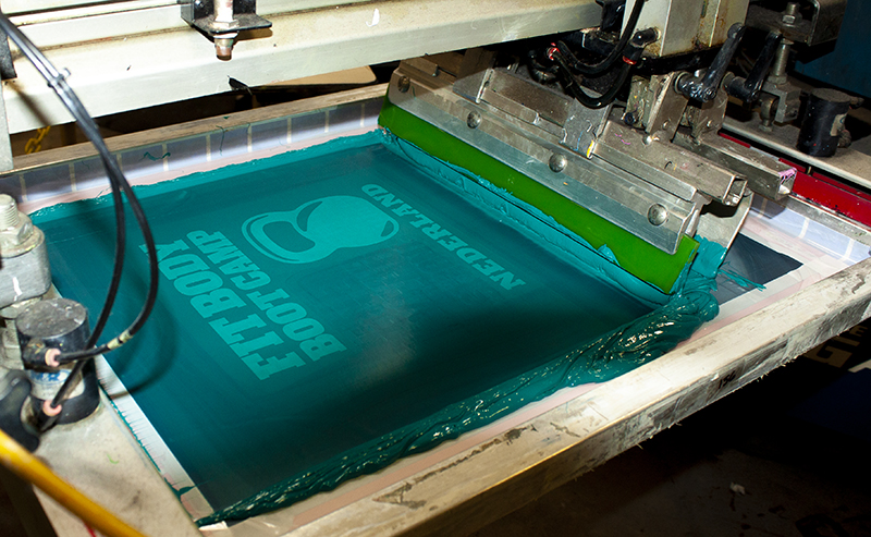 fitbody Boot Camp screen being printed on tshirts with with teal ink on screen