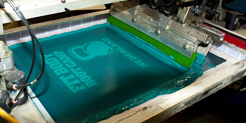 fitbody Boot Camp screen being printed on tshirts with with teal ink on screen